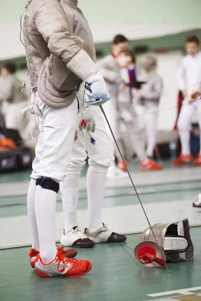 Fencer în costum alb cu mască de protecție și rapier pe podea — Fotografie, imagine de stoc