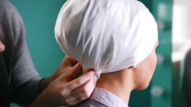 İslam Türban, ayna yakınındaki bir düğün için hazırlanıyor bağlamak için iki Müslüman kadın