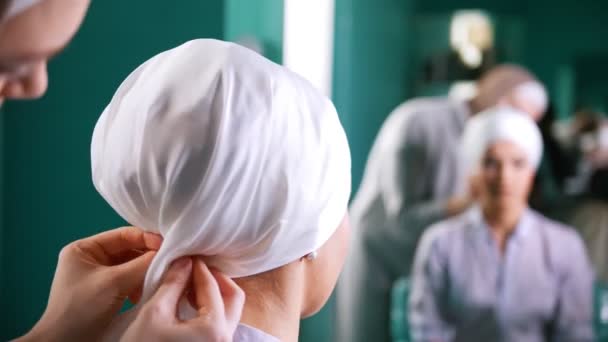 Una donna musulmana che lega il turbante per un bellissimo modello — Video Stock