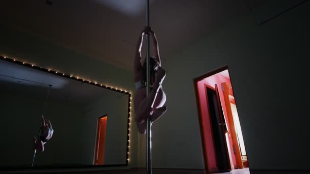 Kvinnliga påle dansanden snurrar på en stolpe i en studio — Stockvideo