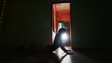Karanlık odada dar giysili siluet dans eden kadın