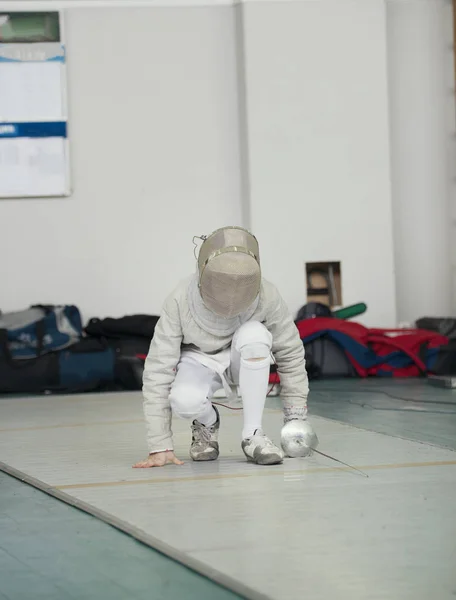 Fencer în costum alb cu rapier și mască de protecție se ridică — Fotografie, imagine de stoc