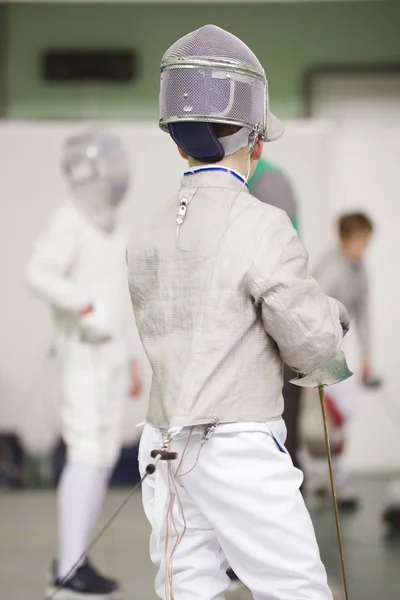 Tânăr participant la turneul de garduri în haine albe și mască de protecție la turneul de garduri — Fotografie, imagine de stoc