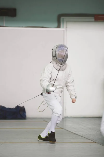 Muchacho adolescente esgrima en traje especial en la competencia de esgrima con estoque listo para la lucha — Foto de Stock