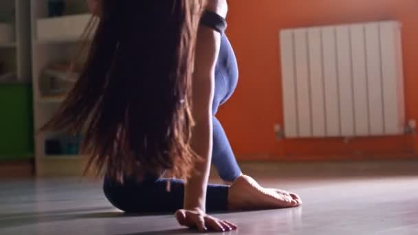 Женщина с длинными волосами танцует с шестом в фитнес-классе — стоковое видео