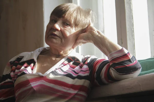 Porträtt av lycklig äldre kvinna hemma nära fönster — Stockfoto
