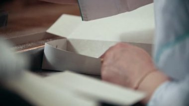 İşçinin şeker kutusunda üretim satırından şeker rafinerisinde koyar