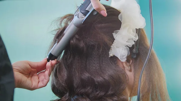 Professionelle Friseurin macht lockiges Haar für schöne Frau — Stockfoto