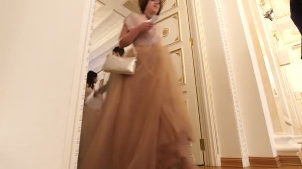 KAZAN, RUSIA - 30 DE MARZO DE 2018: Fiesta de baile en el ayuntamiento - parejas jóvenes en los exuberantes vestidos que vienen en la pelota de recreación — Vídeo de stock