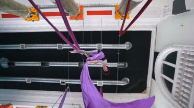 Havadaki bir hava ipek için eliyle tutarak bir jimnastik öğeleri esnek kadın gerçekleştirir