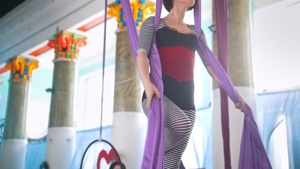 Молода жінка робить гімнастичні елементи на повітряному шовку — стокове відео