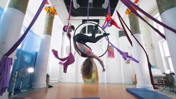 Grace kvinnor kretsande på aerial hoop och silk i en studio — Stockvideo