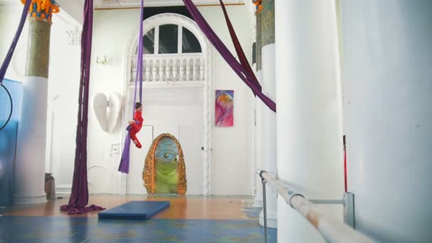 Прекрасная воздушная гимнастка кружит на воздушном шелке в студии — стоковое видео