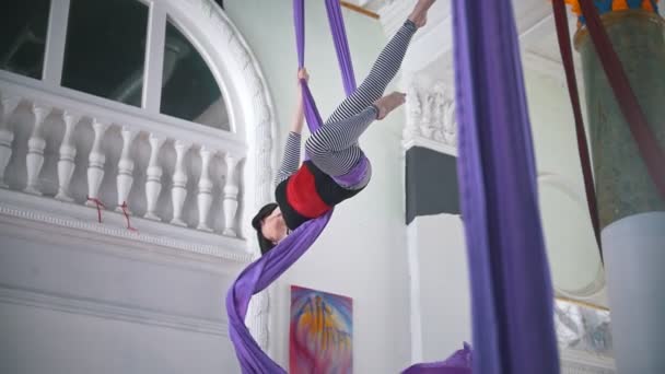 Belle femme gymnaste de l'air exerçant sur la soie aérienne dans un studio — Video