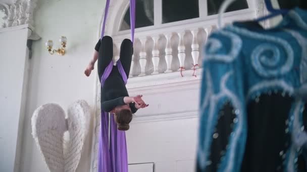 Flexible woman performs a twine in the air hanging on aerial silk — Stock Video