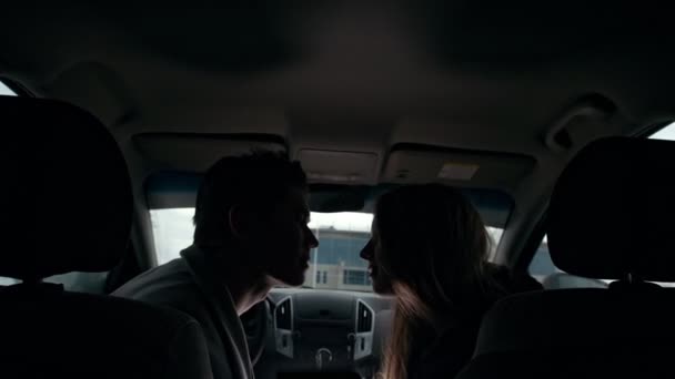 Jovem casal bonito abraçando e beijando em um carro — Vídeo de Stock