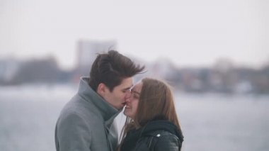 Mutlu genç erkek ve kadın üzerinde riverside öpüşme