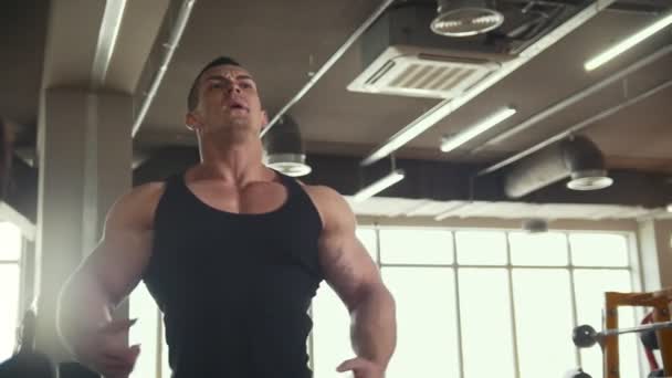 Uomo forte bodybuilder vicino specchio in palestra posa e mostra i muscoli — Video Stock