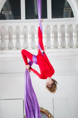 Hava ipek üzerinde asılı bir egzersiz genç çekici hava jimnastikçi gerçekleştirir
