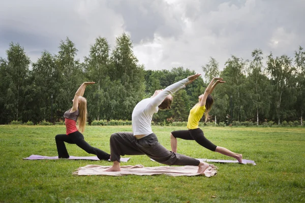 Treinamento no parque - instrutor mostra exercício de flexibilidade para grupo de meninas no parque — Fotografia de Stock