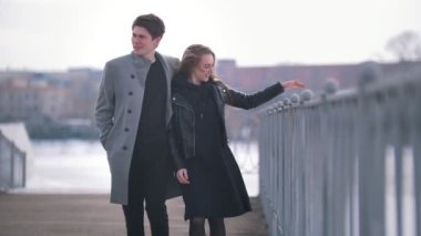 Bulutlu bir günde genç beyaz adam ve yürüyen kadın sarıldı