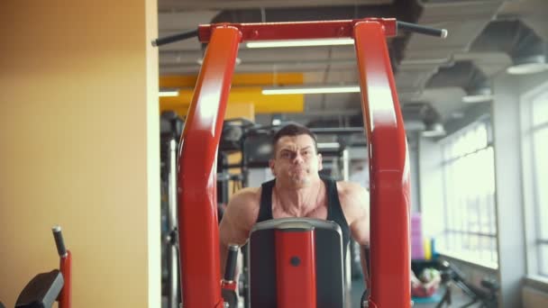 Gespierde sterke man werkt zijn biceps als onderdeel van de oefeningsprogramma in een sportschool — Stockvideo