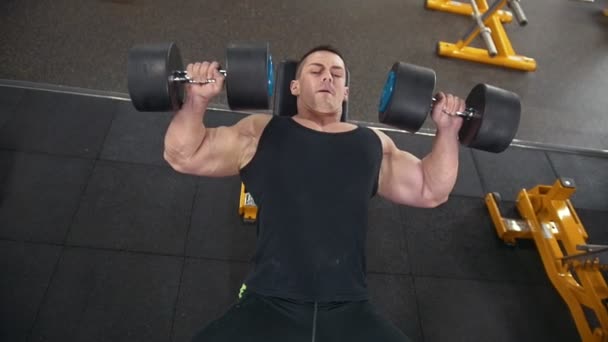 Bello uomo muscoloso fa esercizi manubri in una palestra — Video Stock