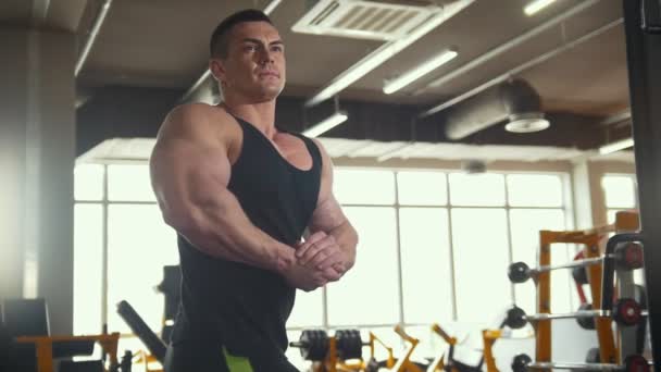 Muskulös ung man värmer upp framför en spegel i träningspass rum — Stockvideo