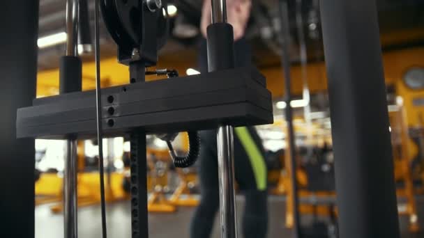 Sports equipment in front of muscular bodybuilder training in a workout room — Stock Video