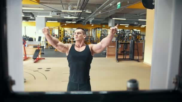Hombre musculoso fuerte en el entrenamiento con pesas en un gimnasio — Vídeo de stock