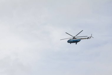 Yüksek gri gökyüzüne uçan helikopter