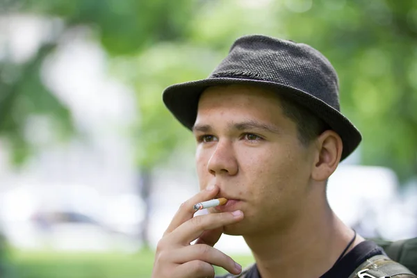 Genç adam duman sigara yaz Park portresi — Stok fotoğraf