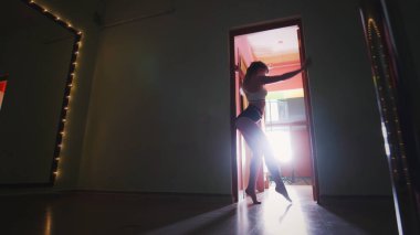 Güzel kadın direk dansör dar giysiler ile şekil üzerinde kutup dans