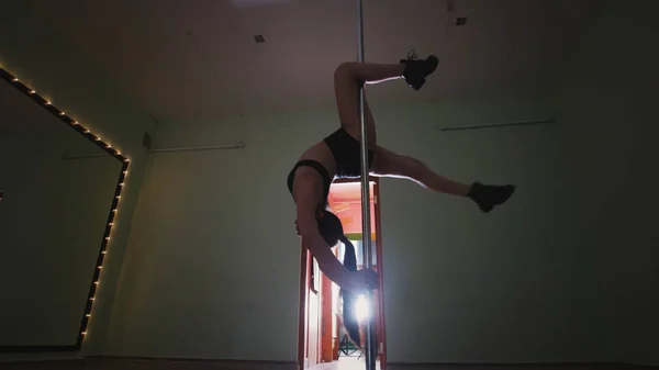 Attraktiv ung kvinna pole dansare i åtsittande kläder dansar på stolpen — Stockfoto
