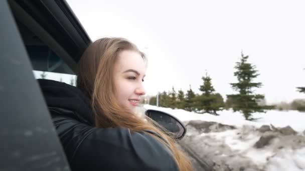 Молодая женщина наклоняется к окну автомобиля, восхищаясь на открытом воздухе — стоковое видео