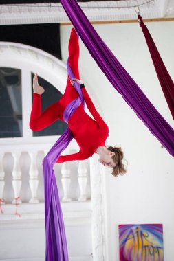 Genç çekici kadın baş aşağı hava ipek üzerinde asılı