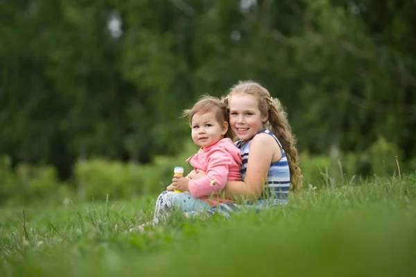 Dvě děti sestry hrají v parku, venku — Stock fotografie