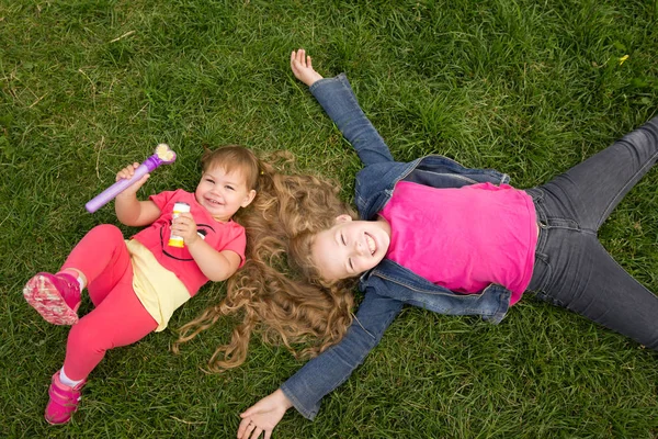 緑の芝生、公園屋外 - 上面に 2 人の姉妹の肖像 — ストック写真