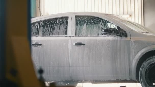 Carro está lavando com espuma de limpeza na instalação de lavagem de carro — Vídeo de Stock