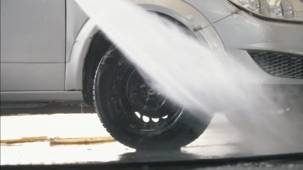Trabajador lavando el salón de coches con manguera de agua — Vídeo de stock