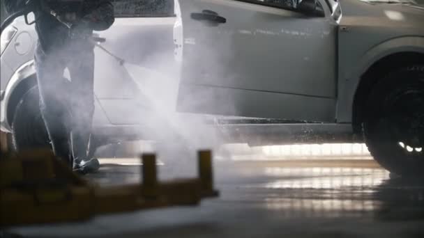 Uomo lavoratore pulizia l'auto con tubo dell'acqua — Video Stock