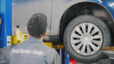 Servis istasyonu asansörde mekanik car yakınındaki arka görünüm