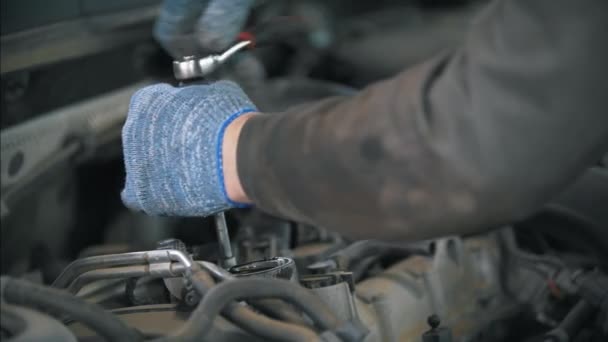 Mechaniker in Handschuhen mit Schraubenschlüssel demontieren das Auto — Stockvideo