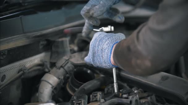 Automechaniker in Handschuhen wickeln Schraubenschlüssel in Autoteile — Stockvideo
