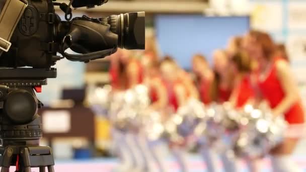 Camera in front of dancing cheerleaders at the karate tornament