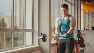 Halter güneşli spor salonunda yapan güçlü vücut geliştirmeci