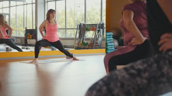 Instructor de fitness entrena a las mujeres con sobrepeso en un gimnasio — Foto de Stock
