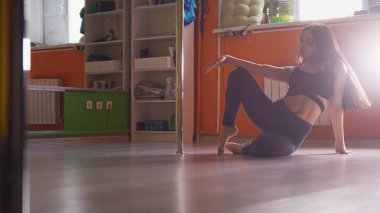 Seksi siyah saçlı kız direk dansör bir stüdyoda eğitim