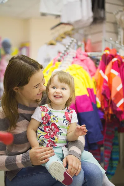 Boldog asszony kislányom ruhanemű szupermarketben — Stock Fotó