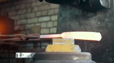 Erimiş metal bir demirci elinde baskı altında işlenir